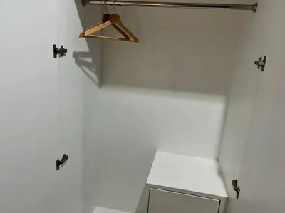 a bathroom with a toilet and a hanger on a wall at Anwari Hotel in Bangkok