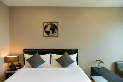 a bedroom with a large white bed with pillows at NORN Canalside Bangkok Hotel โรงแรมนอนริมคลอง in Bangkok Noi