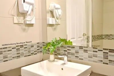a bathroom with a sink and a mirror at NORN Canalside Bangkok Hotel โรงแรมนอนริมคลอง in Bangkok Noi