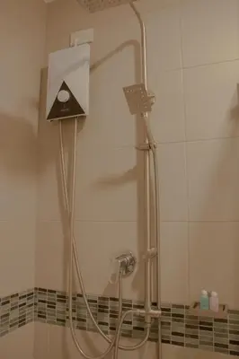 a shower in a bathroom with a shower head at NORN Canalside Bangkok Hotel โรงแรมนอนริมคลอง in Bangkok Noi