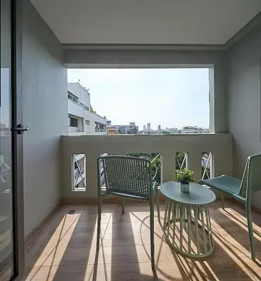 a balcony with a table and chairs and a window at The Path Siam in Bangkok
