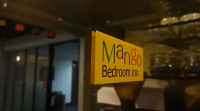 a yellow sign on a window of a restaurant at Mango Bedroom Inn in Bangkok