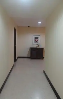 an empty room with a desk and a door at Mango Bedroom Inn in Bangkok