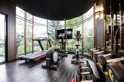 a fitness room with a gym with a large window at The One Smart Living in Bangkok