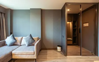 a living room with a couch and a glass door at The One Smart Living in Bangkok