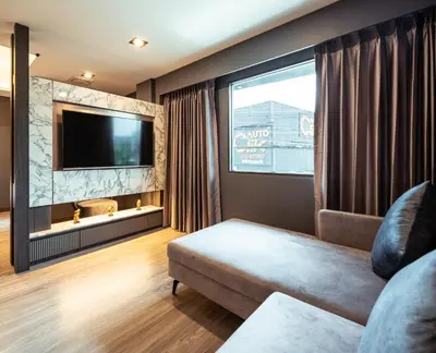 a living room with a couch and a flat screen tv at The One Smart Living in Bangkok