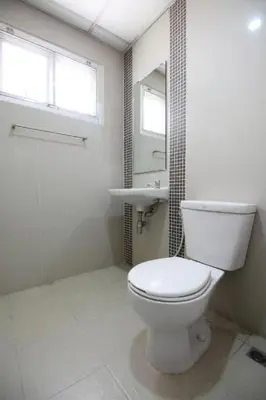 a white bathroom with a toilet and a sink at Mee sook Hotel and Residence in Nonthaburi