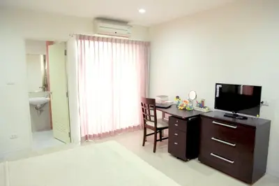 a room with a desk and a television in a room at Mee sook Hotel and Residence in Nonthaburi