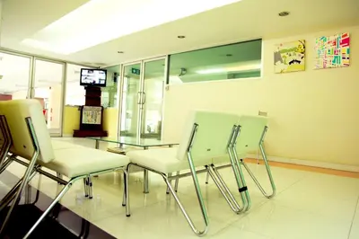 a waiting room with three chairs and a glass table at Mee sook Hotel and Residence in Nonthaburi