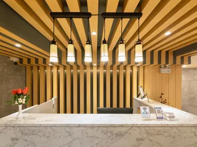 a lobby with a counter with flowers and lights at Watergate City in Bangkok