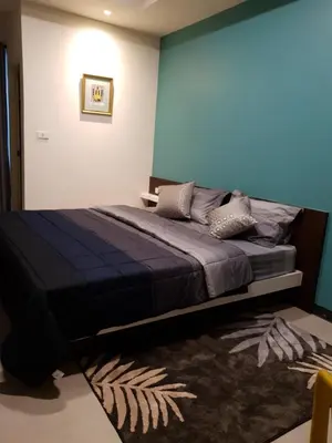 a bedroom with a bed with a blue wall at 552 Residence in Bangkok