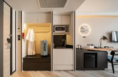 a kitchen with a refrigerator and a microwave at Seekers Finders Rama IV Hotel SureStay Collection by BW in Bangkok