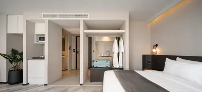 a bedroom with a large bed and a bathroom at Seekers Finders Rama IV Hotel SureStay Collection by BW in Bangkok