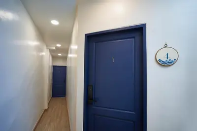 a hallway with a blue door with a sign on it at Sweet's Escape in Bangkok