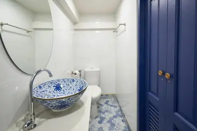 a bathroom with a blue and white sink and a toilet at Sweet's Escape in Bangkok