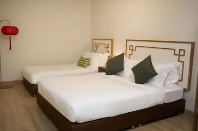 two beds in a hotel room with white sheets at Sweet's Escape in Bangkok