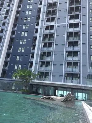 a large apartment building with a swimming pool in front of it at New condominium on Sukhumvit Road 