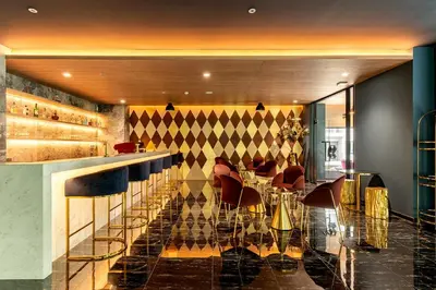 a restaurant with a bar with chairs and a counter at Thaya Hotel Bangkok in Bangkok