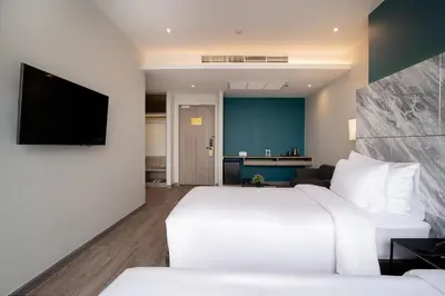 a hotel room with a bed and a flat screen tv at Thaya Hotel Bangkok in Bangkok