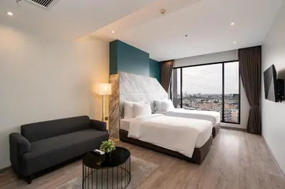 a bedroom with a bed and a couch at Thaya Hotel Bangkok in Bangkok