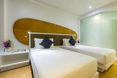 a hotel room with two beds and a headboard at Hotel Icon Bangkok Sukhumvit 2 in Bangkok