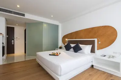 a bedroom with a large white bed with a wooden headboard at Hotel Icon Bangkok Sukhumvit 2 in Bangkok