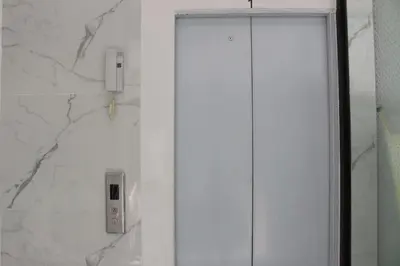 a bathroom with a shower with a phone on the wall at Nato house Ekkamai in Bangkok