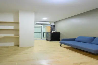 a living room with a blue couch in a room at Zayn Express & Suites in Bangkok