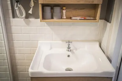 a white sink in a bathroom with a shelf at Canal View Lo-ha guest house, Contactless Check-in in Bangkok