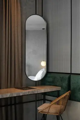 a mirror and a chair in a room at Goose Living in Bangkok