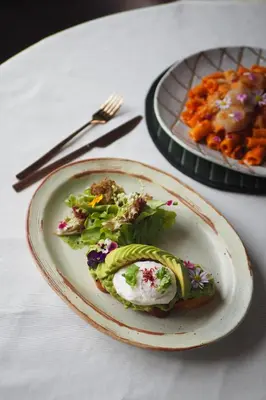 a plate of food on a table with a plate of food at Goose Living in Bangkok