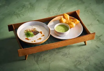 a tray with a plate of food and a bowl of soup at Goose Living in Bangkok