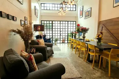 a living room with a long table and chairs at Beautiful 5 Story Family House in Bangkok