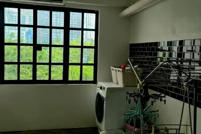 a laundry room with a washing machine and windows at Beautiful 5 Story Family House in Bangkok