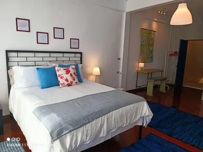 a bedroom with a large bed with blue pillows at Big Groups Heaven in Central Location in Bangkok