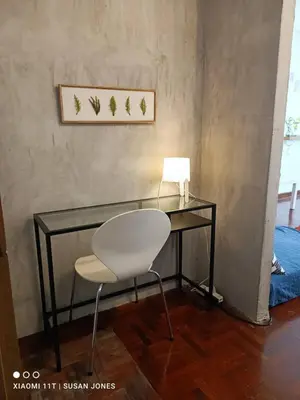a glass desk with a white chair and a lamp at Big Groups Heaven in Central Location in Bangkok