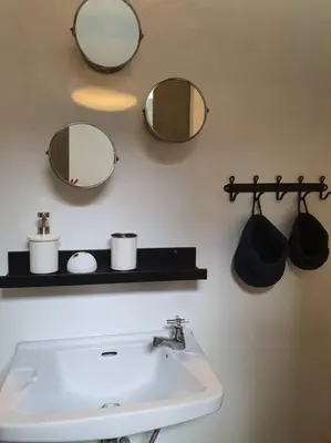a bathroom with a sink and two mirrors on the wall at Great House for Families and Big Groups in Bangkok