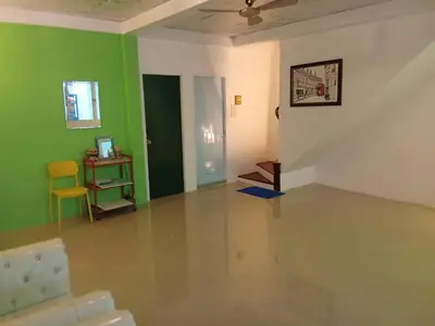a living room with green walls and a yellow chair at Ban Suanlum in Bangkok