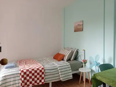 a bedroom with a bed with a checkered blanket at Ban Suanlum in Bangkok