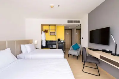 a hotel room with two beds and a desk at Best Western Nada Don Mueang Airport hotel in Bangkok