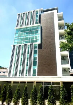 a tall building with trees in front of it at Wealth 30th in Bangkok