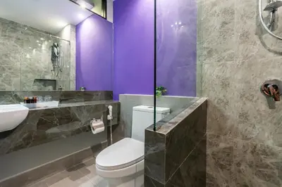 a bathroom with a toilet and a sink and purple walls at Hi Sotel Victory Monument in Bangkok