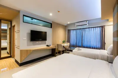 a hotel room with two beds and a flat screen tv at Hi Sotel Victory Monument in Bangkok