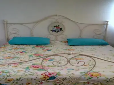 a bed with two blue pillows on top of it at T8 Guest House Don Mueang Challenger in Ban Song Hong