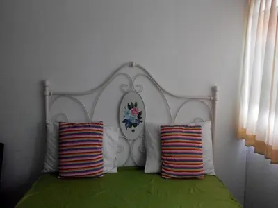 a bed with a white headboard and two pillows at T8 Guest House Don Mueang Challenger in Ban Song Hong