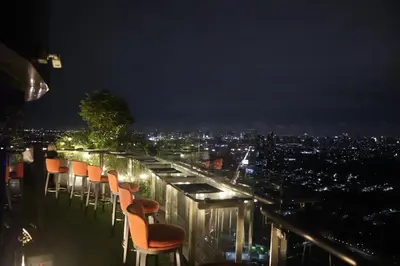 a group of chairs sitting on a balcony at night at Oakwood Suites Tiwanon Bangkok in Nonthaburi