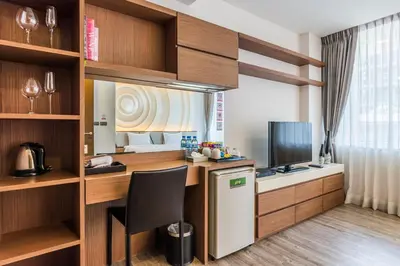 a kitchen with a desk and a television in a room at Olive Hotel Bangkok 64 in Bangkok