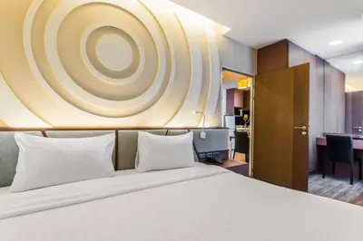 a hotel room with a bed with white pillows at Olive Hotel Bangkok 64 in Bangkok