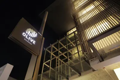 a sign on the side of a building at night at Olive Hotel Bangkok 64 in Bangkok