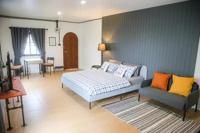 a bedroom with a bed and a couch at SLEEP SLEEP SUANPHAK Homestay in Ban Khlong Bang Sai